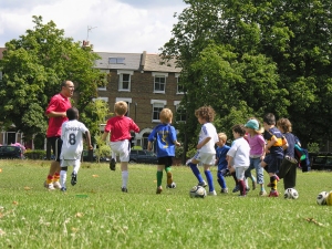 Little kids on football training in the park